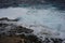 Tranquil ocean landscape with white-capped waves and jagged rocks emerging from the depths