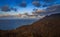 Tranquil ocean view overlooking a hillside with picturesque clouds at sunset