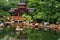 Tranquil oriental garden with pond, Zen view of calm green pond water with oriental house and rocks on shore, Hong Kong, Nan Lian