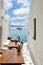 Tranquil outdoor dining area in Mykonos with a sailboat in the background.