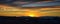 Tranquil panoramia scene of red sun and orange sky sunset over the Rocky Mountains in Colorado by Denver