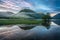 Tranquil reflections in a lake at sunrise beside mountains