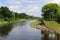 tranquil riparian river water tree lined waterway dam clouds rural landscape blue sky countryside