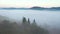 Tranquil rural landscape is covered with thick fog from a bird`s eye view. Filmed in UHD 4k video