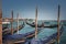 Tranquil scene of gondolas docked in Venice surrounded by serene water and buildings