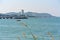 Tranquil Scenery of Small Boat in the Sea with City Buildings on Background