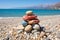 Tranquil seascape with balanced stone stack against backdrop of clear sky and serene waters