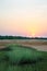 Tranquil sunset over wetland with green grass in rural area of Guinea Bissau, Africa