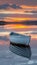 Tranquil sunset seascape with empty wooden rowboat drifting on calm and serene waters