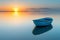 Tranquil sunset seascape with wooden rowboat adrift in serene and calm waters at twilight