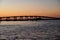 Tranquil sunset view of a bridge stretching across a tranquil body of water