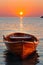 Tranquil sunset view over ocean with serene empty wooden rowboat on still calm water