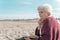 Tranquil thoughtful lady with the diary seated on the beach