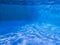 Tranquil underwater blue pool floor and sides with ripples light and shadows