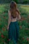 Tranquil vertical shot of a girl in the green poppy field