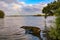 Tranquil water scene with partially sunk row boat in Wallis Lake at Forster NSW with rainbow in background