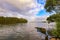 Tranquil water scene with partially sunk row boat in Wallis Lake at Forster NSW with rainbow in background