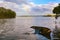 Tranquil water scene with partially sunk row boat in Wallis Lake at Forster NSW with rainbow in background