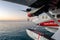 Trans Maldivian Airways seaplane Twin Otter Series 400 floating on the ocean surface with sunset in the background