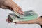 During the transaction, a woman`s hand looks through a bundle of paper banknotes