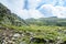 The Transfagarasan road in Fagaras mountains, Carpathians with green grass and rocks, peaks in the clouds