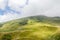 The Transfagarasan road in Fagaras mountains, Carpathians with green grass and rocks, peaks in the clouds