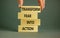 Transform fear into action symbol. Businessman holds wooden blocks with words `Transform fear into action`. Beautiful grey