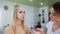 Transformation. In the trendy beauty salon, a professional makeup artist prepares the image for an attractive blonde.