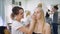 Transformation. In the trendy beauty salon, a professional makeup artist prepares the image for an attractive blonde.