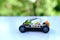 Transformer car with manipulator, assembled from designer parts, beautiful green background of trees with bokeh, concept of