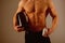 Transforming body with diet. Anabolic hormone increases muscle strength. Strong man hold vitamin bottles. Man with six