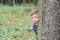 Transforming fear into freedom. Little boy feel nasty fear to be lost in wood. Little boy hide behind tree in fear