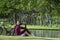 Transgender woman in sportswear sitting beside the pond