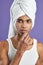 Transgender young man apply lips balsam in towel portrait. Afroamerican model use lipstick balm