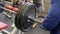 Transition shot of determined muscular man putting heavy plates on barbell and lifting in gym.Young sporty man preparing