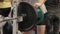 Transition shot of determined muscular man putting heavy plates on barbell and lifting in gym.Young sporty man preparing