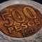 Translation: 500 pesos. Coin of 500 Chilean pesos closeup. Peso of Chile. News about economy or banking. Loan and credit. Money