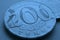 Translation: tenge. Kazakh coins. Blue tinted money background. Coin 200 tenge close up. Economy and National Bank of Kazakhstan.