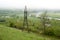 Transmission tower. Giant cloud. Bridge over river. Foggy weather.