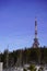 Transmitter and repeater signal in the woods against the blue sky and clouds, vertical. Telecommunication tower with antennas or