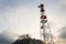 Transmitters and aerials on telecommunication tower, sunset in snowy country