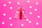 Transparent ampoules with liquid medicine are on pink background around tablets which form polka dots pattern. Concept photo of co