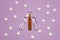 Transparent ampoules with liquid medicine are on purple background around tablets which form polka dots pattern. Concept photo of