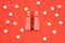 Transparent ampoules with liquid medicine are on red background around tablets which form polka dots pattern. Concept photo of com