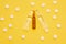 Transparent ampoules with liquid medicine are on yellow background around tablets which form polka dots pattern. Concept photo of