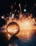 Transparent ball on the wet ground surface reflecting the bright firework in the background