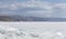 Transparent blue ice hummocks on lake Baikal shore. Siberia winter landscape view. Snow-covered ice of the lake. Big