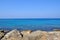 Transparent, blue, turquoise sea against the background of mountains, stones, blue sky