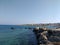 Transparent, blue, turquoise sea against the background of mountains, stones, blue sky