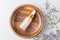 Transparent bottle with beauty serum, hyaluronic acid, 24k gold and vitamins in wooden bowl on marble background. Luxuary home